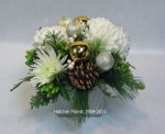A silver ceramic shimmering ceramic base. White Commercial mums and Anastasia mums, two tone gold balls, cones, seasonal pine and fir. let our elves deliver one for you.