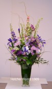 A soft melange of purple, mauve, lavendar and a touch of pink. Mixed foliage such as ruscus, salal, lily grass and curly willow. We have used Larkspur, Anastasia mums, iris, Alstroemeria and roses.