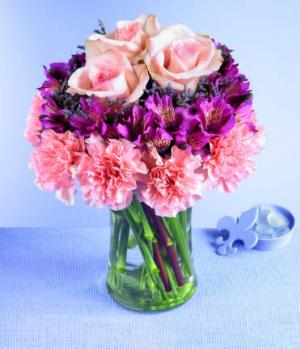 Pretty petals in a tiered design make a unique bouquet. Pink carnations form the first tier; deep lavender alstroemeria fill the center, and three luscious pink roses are the crowning touch. A stylish design for anyone who appreciates something above the ordinary.