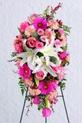 Beautiful standing spray of three white Oriental lilies surrounded by pink Gerbera daisies, pink roses, variegated pink carnations and orchids.We deliver to all Toronto and area funeral homes.