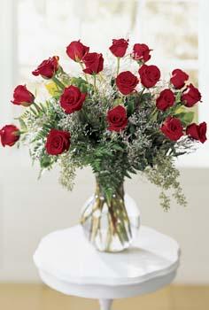 18 roses, limonium and seeded eucalyptus are beautifully arranged in a glass vase. Sure to impress. Available in pink, red, yellow, white or peach. red Freedom roses by Sierra Eco.