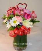 A long lasting mixed Valentine arrangement delivered from our flower shop. Mixed flowers such as alstromeria, carnations, daisies, roses, Anastasia mums and mixed foliage. A Valentine bow and two red hearts. We deliver flowers from our flower shop.