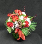 A heavy green oval glass vase designed with red Roses,white Pom pons, baby breath, pine, cedar, gold balls, red metallic berry spray, pine cones, a white Rose and red and white carnations.