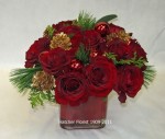 A group of 12 red Freedom roses in a glass cube with pine, fir, gold cones, red glass balls will brighten any office or home setting. The red roses are so rich against the pine and gold cones.