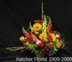 An arrangement of late Summer, early Fall flowers. We use a terra cotta look plastic container. This is a large display of flowers.