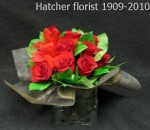 A simple glass cube with 12 red Freedom roses and black cloth wrap around the stems. Very sophisticated, and elegant. The roses are arranged and ready to enjoy.